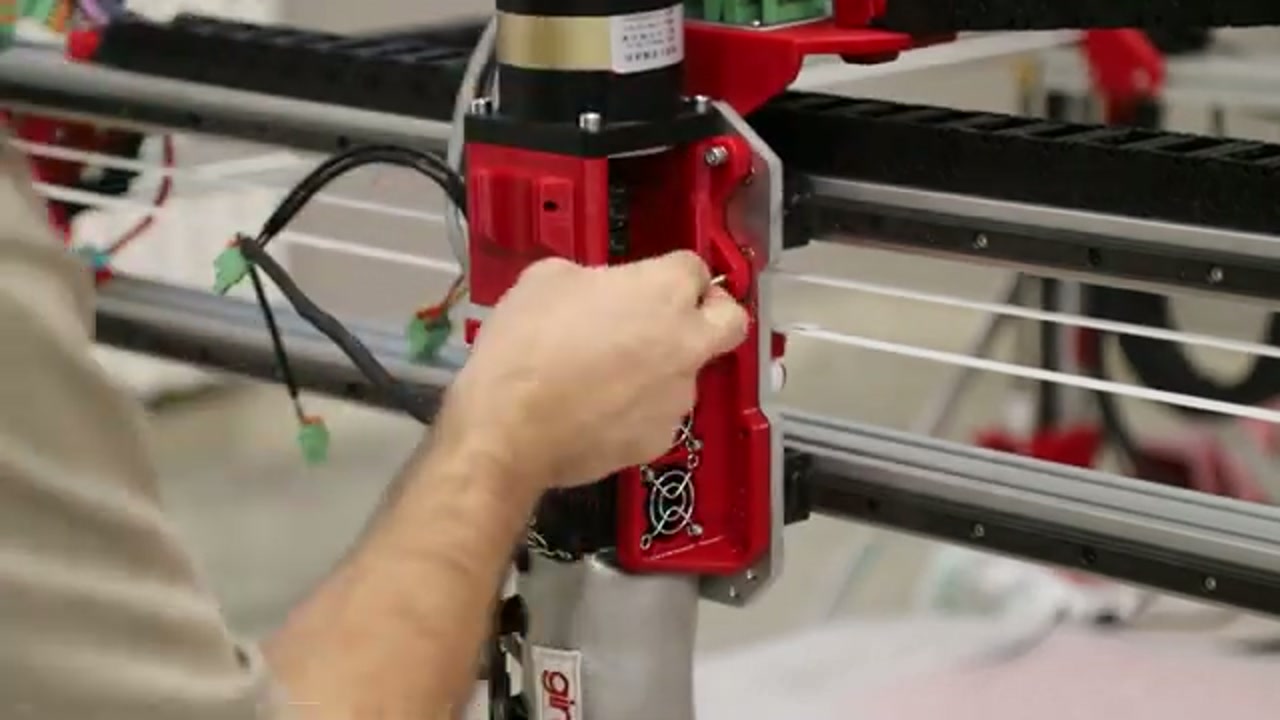 G1 extruder closeup during assembly — red motor, heater zones, linear rail, and corrugated tube connection visible