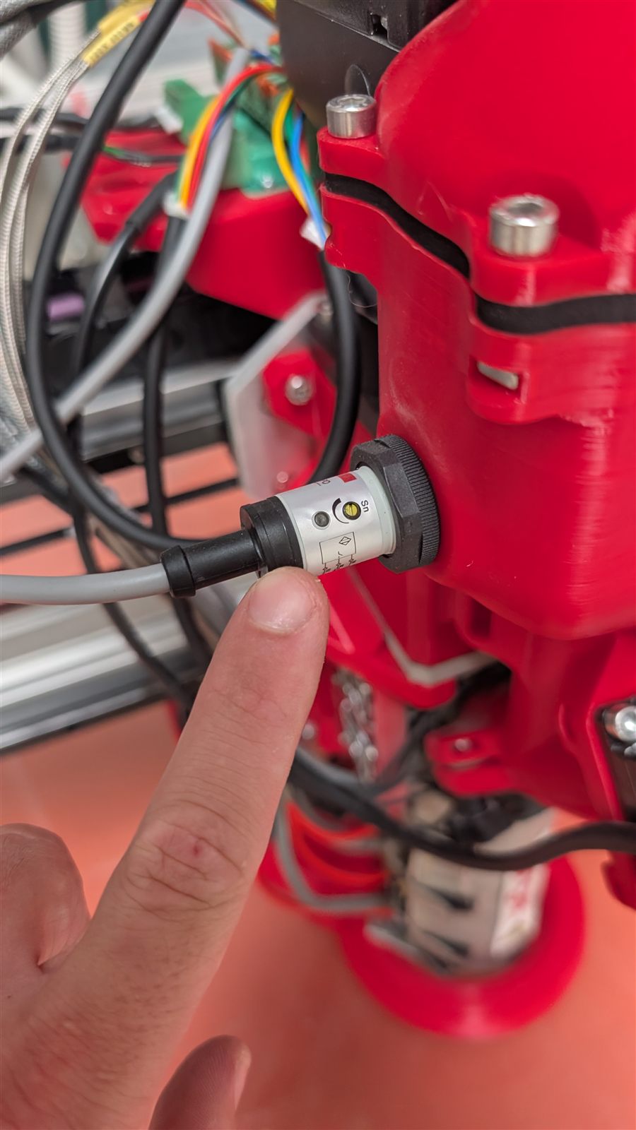 The level probe on the side of the hopper, accessible from outside the machine